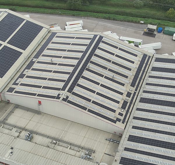 Aerial view of a large Iceland warehouse featuring Ortus Energy rooftop solar panels, showcasing sustainable energy solutions.